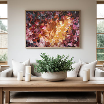 Fiery red and orange abstract flower art print with a natural frame. Hanging in a modern living room.