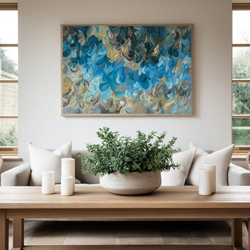 Modern coastal and water inspired abstract art print in blues and ochre yellow. Layers of soft organic shapes in a contemporary impressionist style. Framed in a natural frame and hanging in a modern living room.