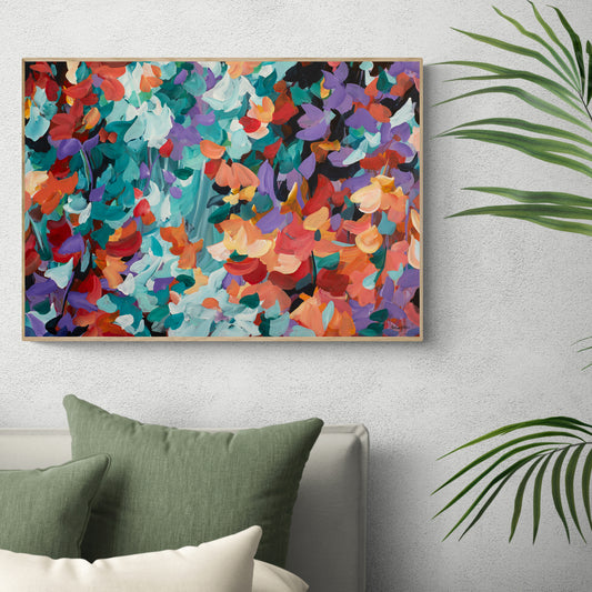 Bright colourful abstract wall art print in purple, red and turquoise. Modern impressionist style of abstract falling leaves in nature. Framed in a natural frame and hanging against a living room wall.