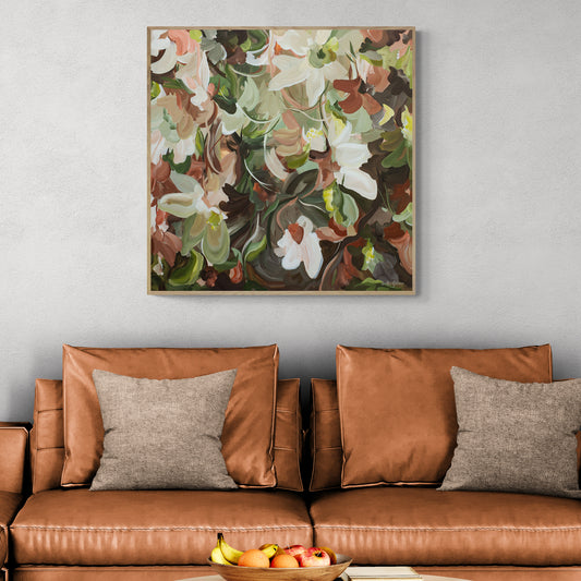 Brown leather sofa with decorative pillows and a colourful floral painting on the wall.